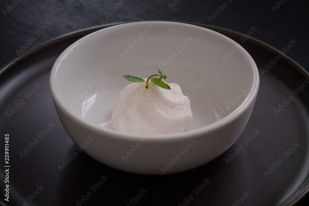 Marshmallow in a plate. Dessert for those who are on a diet. Low-calorie sweets. White plate on a black background Marshmallow in a plate. Dessert for those who are on a diet. Low-calorie sweets. White plate on a black background