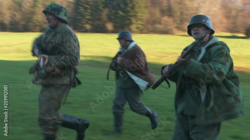 WWII - German soldiers run over meadow photo