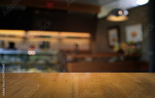 Fototapeta Naklejka Na Ścianę i Meble -  Empty dark wooden table in front of abstract blurred bokeh background of restaurant . can be used for display or montage your products.Mock up for space.