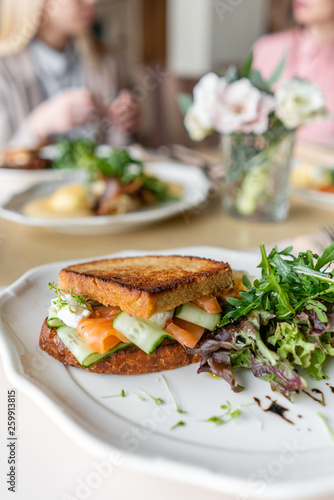 French toast brioche, Sandwich with salmon and cucumber. Light morning Breakfast, fresh warm pastries on table in restaurant