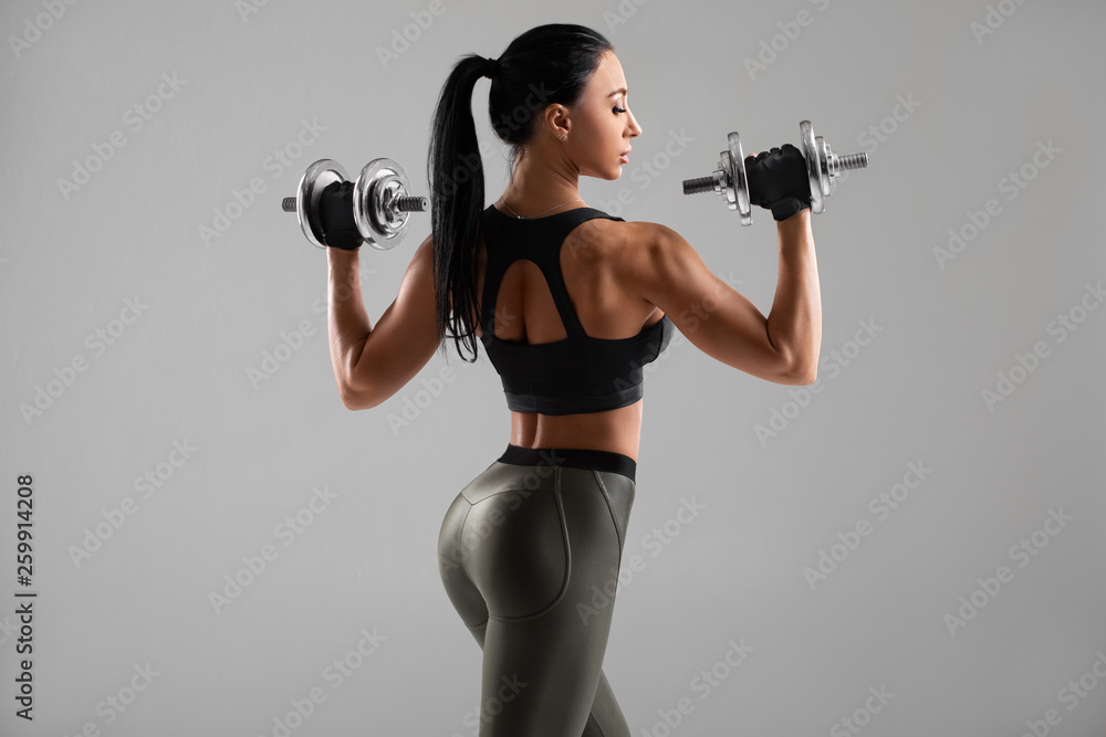 Fitness woman in training muscles of the back with dumbbells Stock Photo by  ©Improvisor 99496950