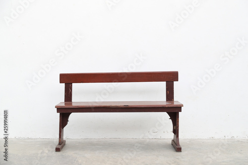 single brown wooden long chair on white cement wall background.
