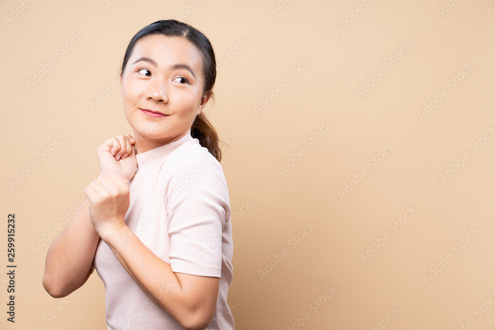 Happy woman thinking and standing isolated over beige brown background Happy woman thinking and standing isolated over beige brown background
