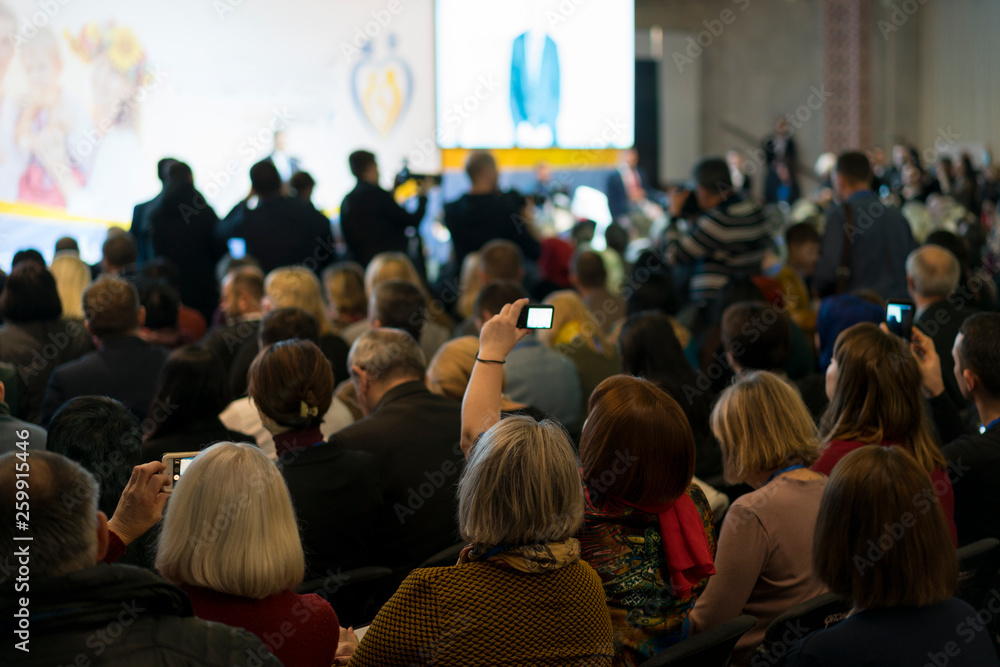 Obraz premium People in the hall listen to the lecturer. Businessman and people Listening on The Conference