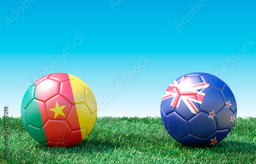 Two soccer balls in flags colors on green grass. Cameroon and New Zealand. 3d image