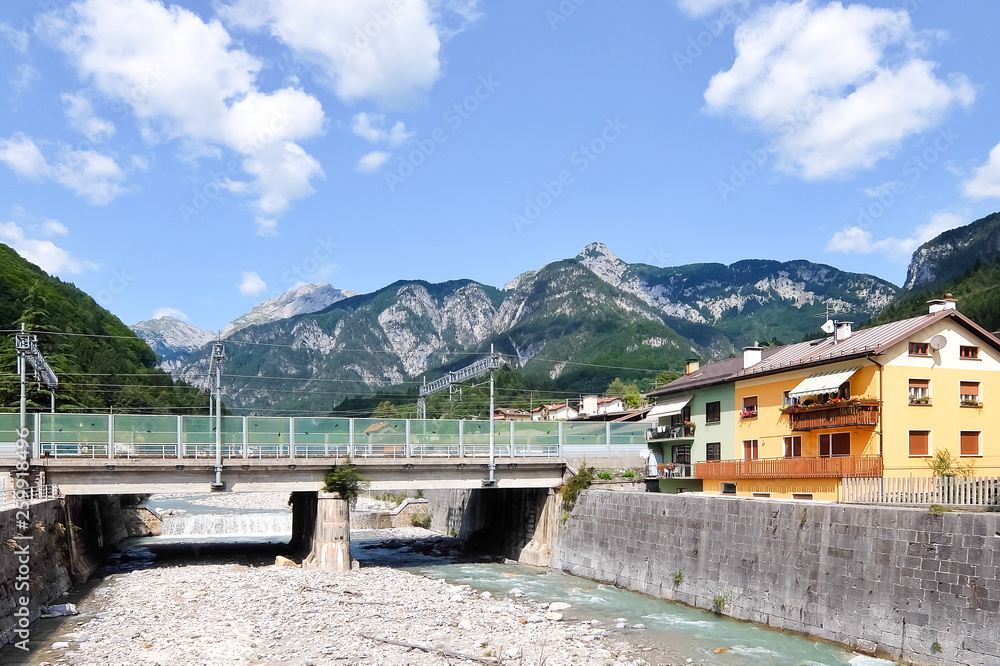 Pontebba, Italy. View of dry river bed Pontebbana in sunny day. Beautiful sky and mountains in background.