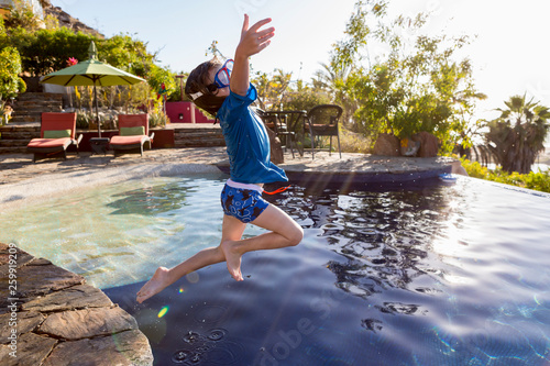 5 year old boy leaping into pool, Todos Santos, Mexico