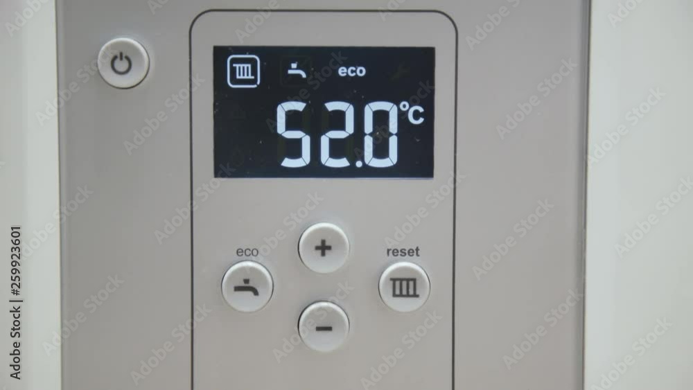 Male finger touches boiler display for temperature control Male finger touches boiler display for temperature control