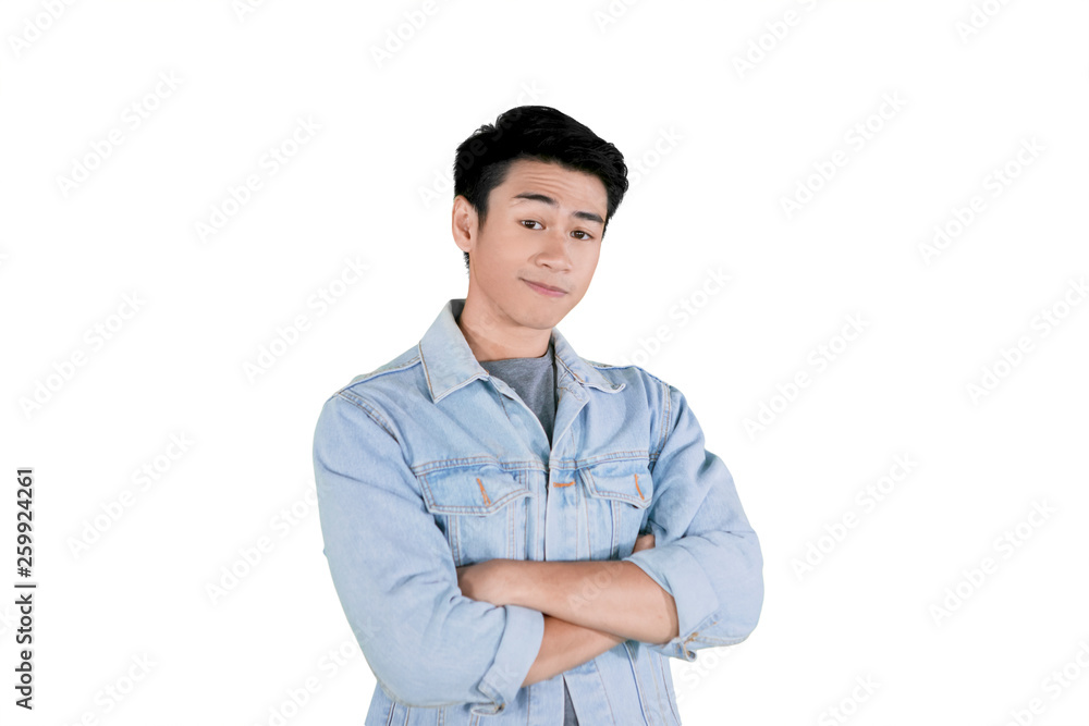 Handsome man stands with crossed arms on studio Handsome man stands with crossed arms on studio