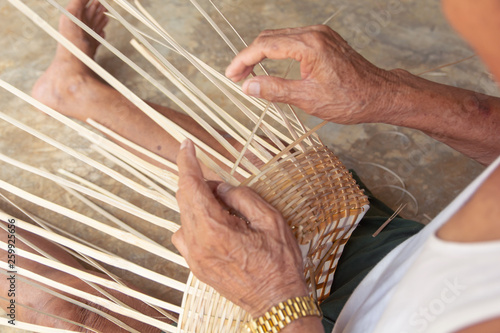 Senior man hands manually weaving bamboo.