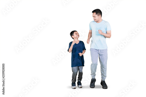 Young father doing exercise run with his son