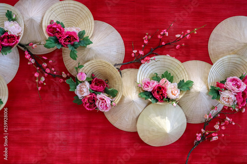 vietnamese cornical hats with flowers in red background photo