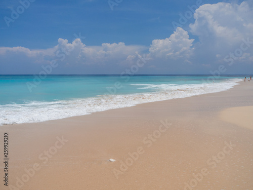 Turquoise waves crash against stones with splashes. Bali.