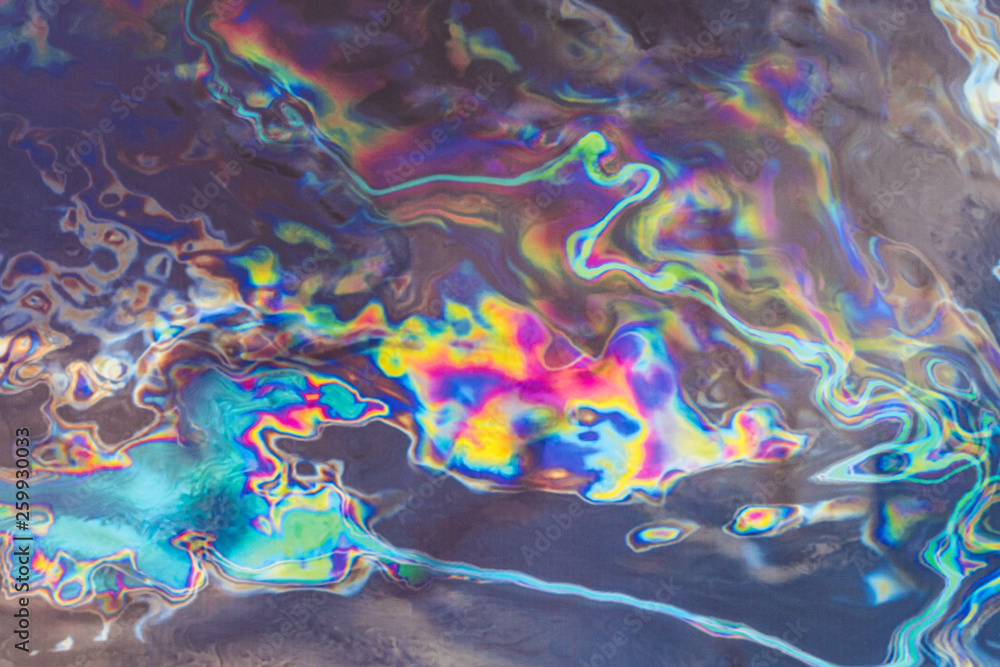 Naklejka premium oil on dark fabric creating fantastic abstract colourful patterns and images
