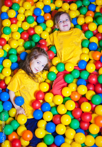 Two Happy little girls playing and having fun at kindergarten with colorful balls in play center