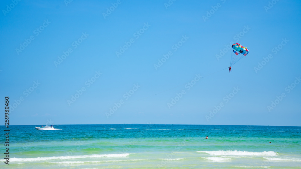Tropical beach background with beautiful blue sea and parachute , crystal clear sea and white sand with palms Tropical beach background with beautiful blue sea and parachute , crystal clear sea and white sand with palms