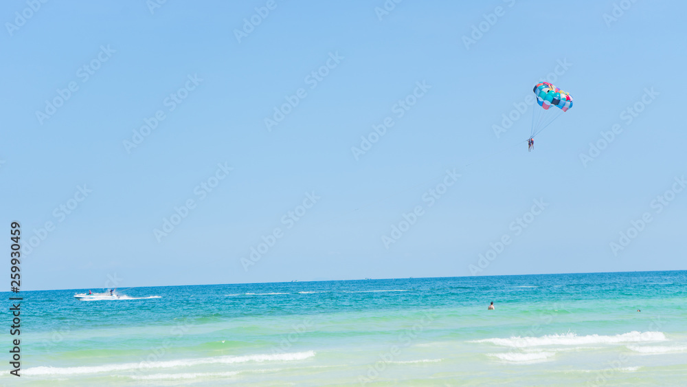 Tropical beach background with beautiful blue sea and parachute , crystal clear sea and white sand with palms Tropical beach background with beautiful blue sea and parachute , crystal clear sea and white sand with palms