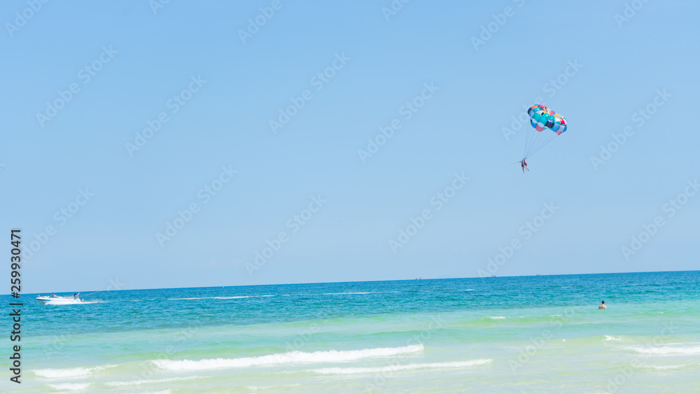 Tropical beach background with beautiful blue sea and parachute , crystal clear sea and white sand with palms Tropical beach background with beautiful blue sea and parachute , crystal clear sea and white sand with palms