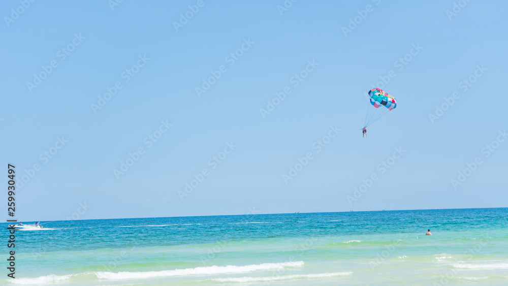 Tropical beach background with beautiful blue sea and parachute , crystal clear sea and white sand with palms Tropical beach background with beautiful blue sea and parachute , crystal clear sea and white sand with palms