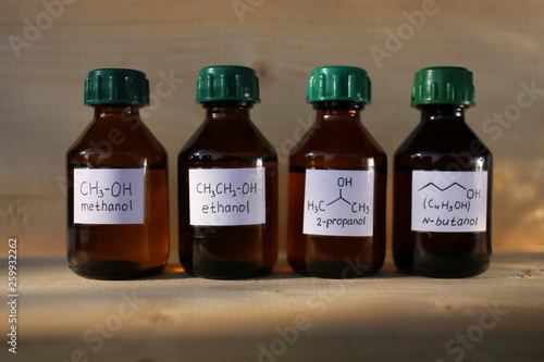 Polar protic solvents alcohols in dark glass bottles: methanol, ethanol, isopropanol, butanol. These substances are used as fuel additives to increase the octane number. photo