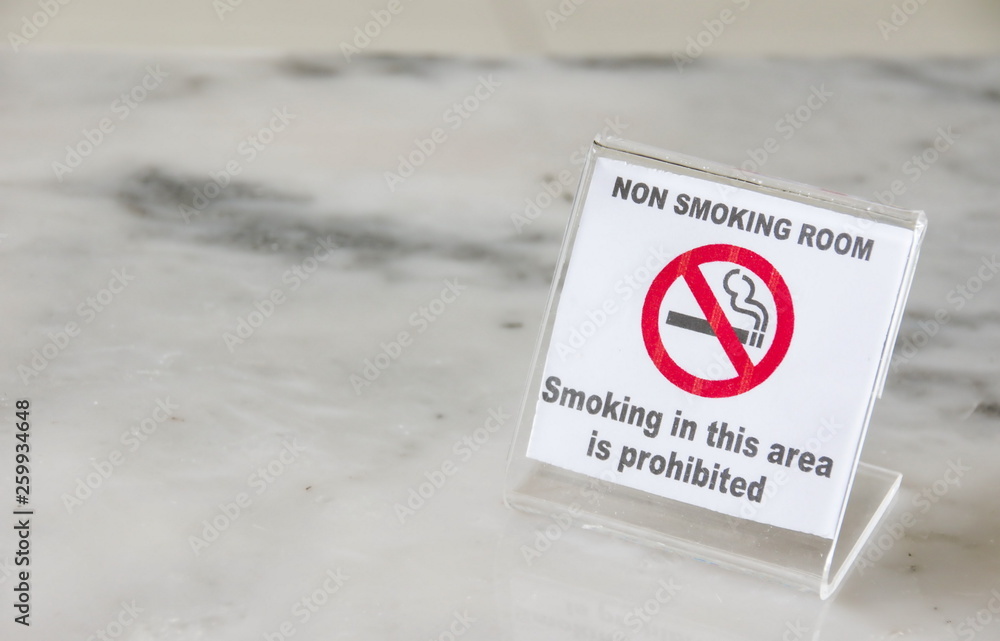 No smoking sign on marble table in hotel room.