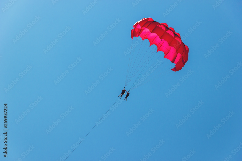 Tourists have fun, parachuting behind a boat, parasailing Tourists have fun, parachuting behind a boat, parasailing