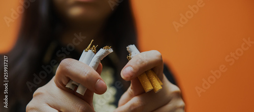 Crop woman breaking cigarette and quitting smoking. Closeup of crop woman splitting cigarette for idea of stop smoking