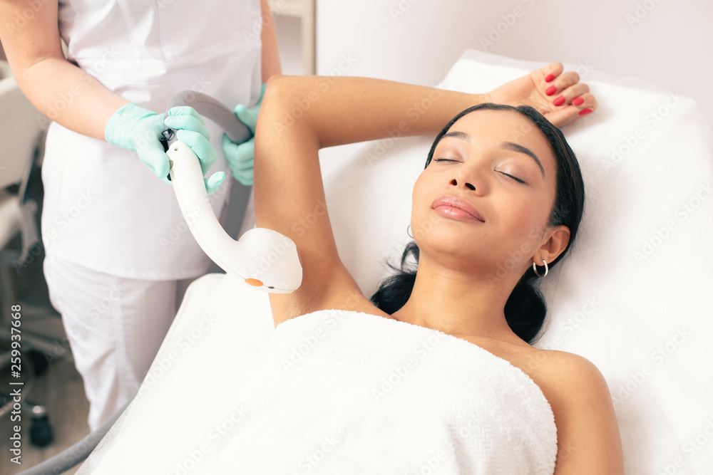 Woman closing her eyes during the laser hair removal Woman closing her eyes during the laser hair removal