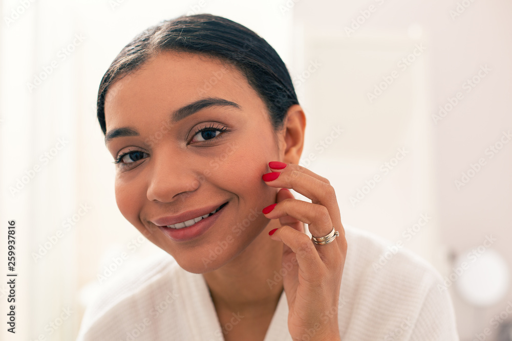 Portrait of young woman with red nails touching her cheek Portrait of young woman with red nails touching her cheek