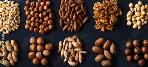 Various nuts on black stone table. Top view frame with copy space