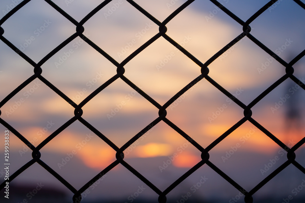 Metal cage square channel on beautiful sunset nature background Metal cage square channel on beautiful sunset nature background