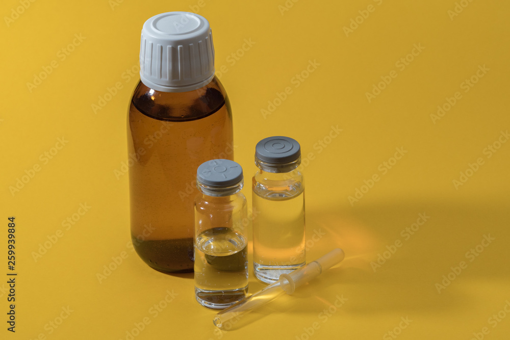 Medicine bottles and pipette on a yellow background. Medicines for individual preparation. Drip medicine. Dropper glass. Bottle Mock-Up Medicine bottles and pipette on a yellow background. Medicines for individual preparation. Drip medicine. Dropper glass. Bottle Mock-Up