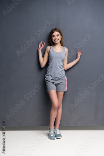 fitness woman. Young sporty Caucasian female model isolated on gray background in full body. © opolja