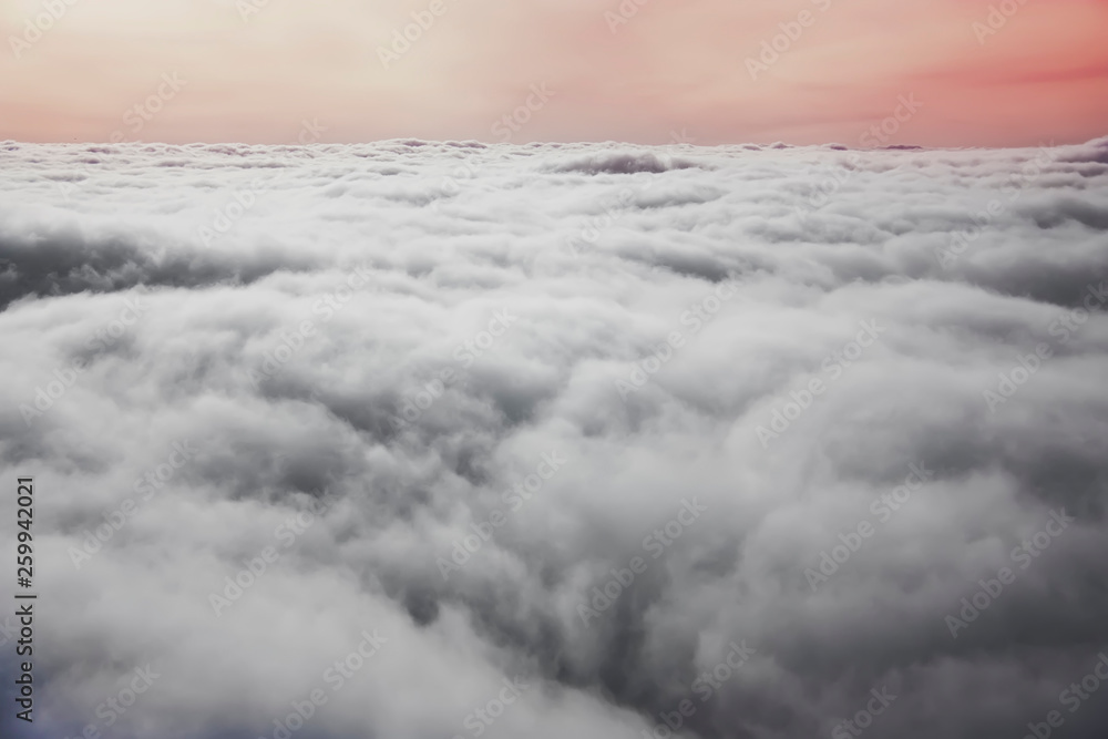 View from plane window. Colorful sunset with white cumulus clouds