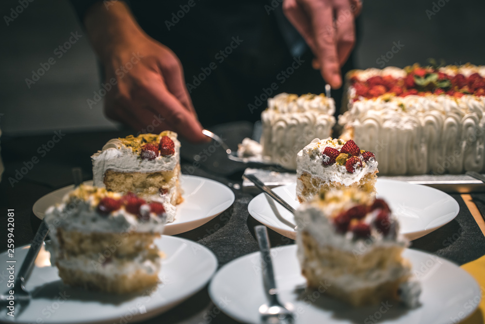 Strawberry and cream birthday cake served by the waiter in ceramic dishes Strawberry and cream birthday cake served by the waiter in ceramic dishes