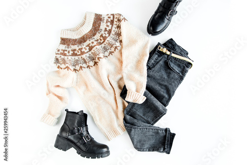 Women fashion clothes and accessories. Feminine youth collage on white background top view. Flat lay female style look with warm sweater, jeans, boot, sunglasses. Top view.