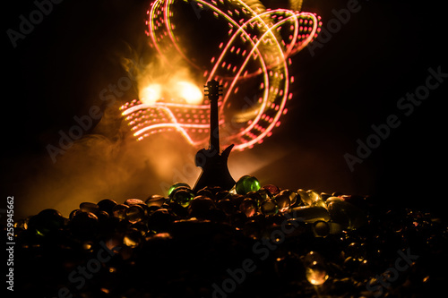 Music concept. Acoustic guitar isolated on a dark background under beam of light with smoke with copy space. Guitar Strings  close up. Selective focus. Fire effects. Surreal guitar