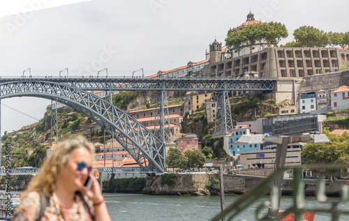A mature tourist woman walks near the famous Don Luis I Bridge in the city of Porto © Óscar