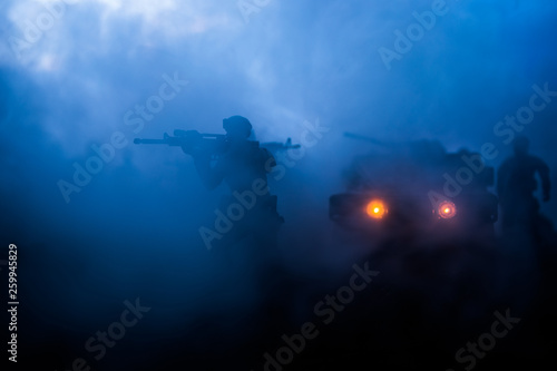Fototapeta Naklejka Na Ścianę i Meble -  War Concept. Military silhouettes fighting scene on war fog sky background, Fighting silhouettes Below Cloudy Skyline At night. Battle scene. Army vehicle with soldiers. army