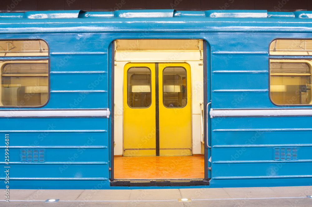 Train with open doors at subway station