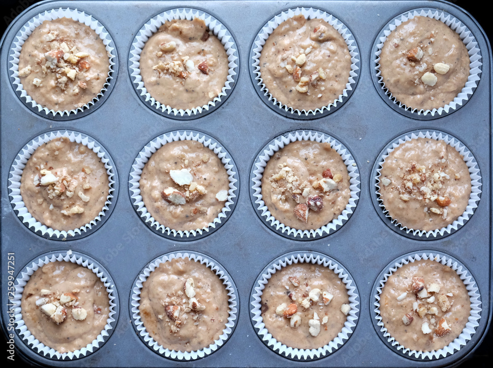 12 cup cakes on a baking tray about to go into the oven 12 cup cakes on a baking tray about to go into the oven