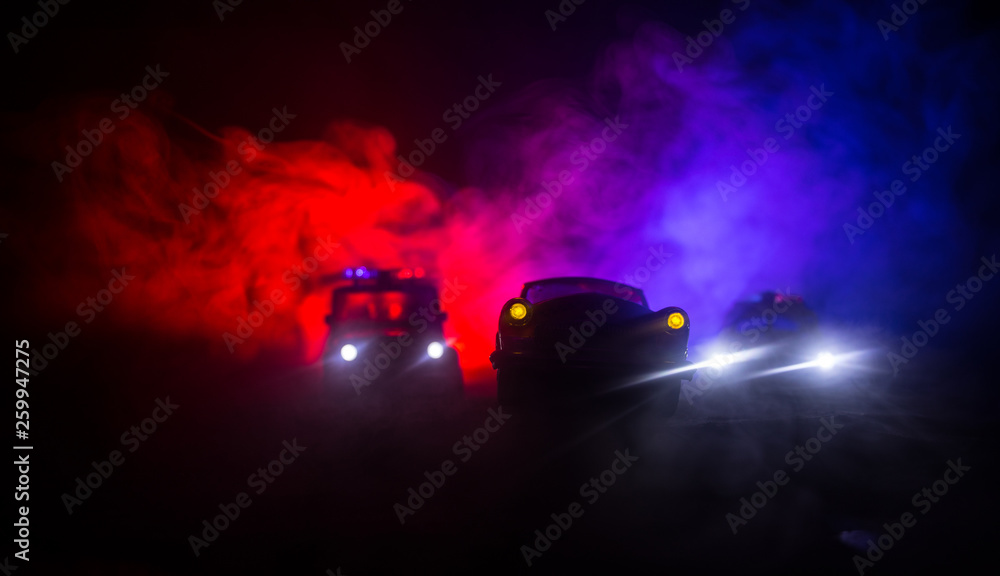 Police car chasing a car at night with fog background. 911 Emergency response police car speeding to scene of crime. Selective focus Police car chasing a car at night with fog background. 911 Emergency response police car speeding to scene of crime. Selective focus