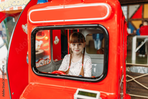 Little girl plays a bus driver, game machine