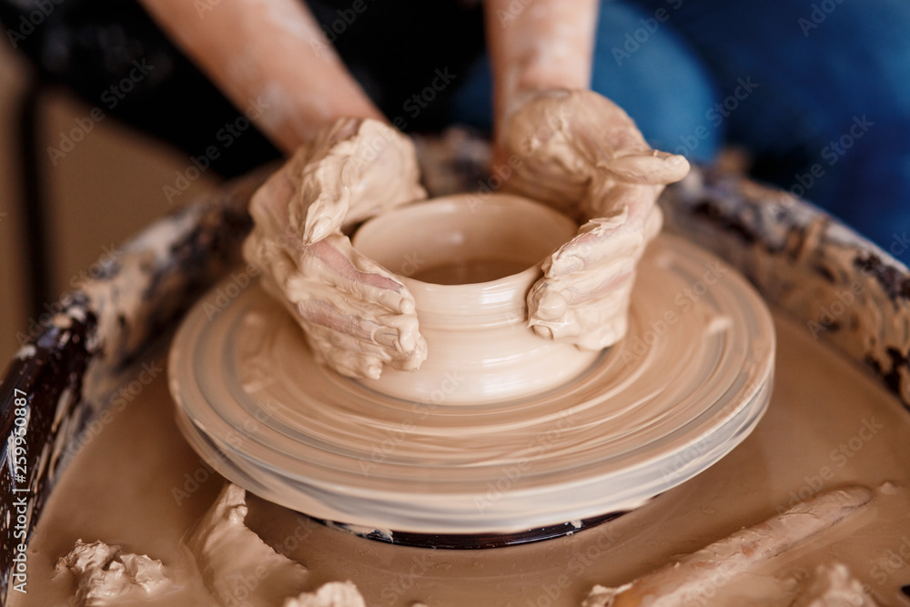 Hands sculpt new utensil on a pottery wheel Hands sculpt new utensil on a pottery wheel