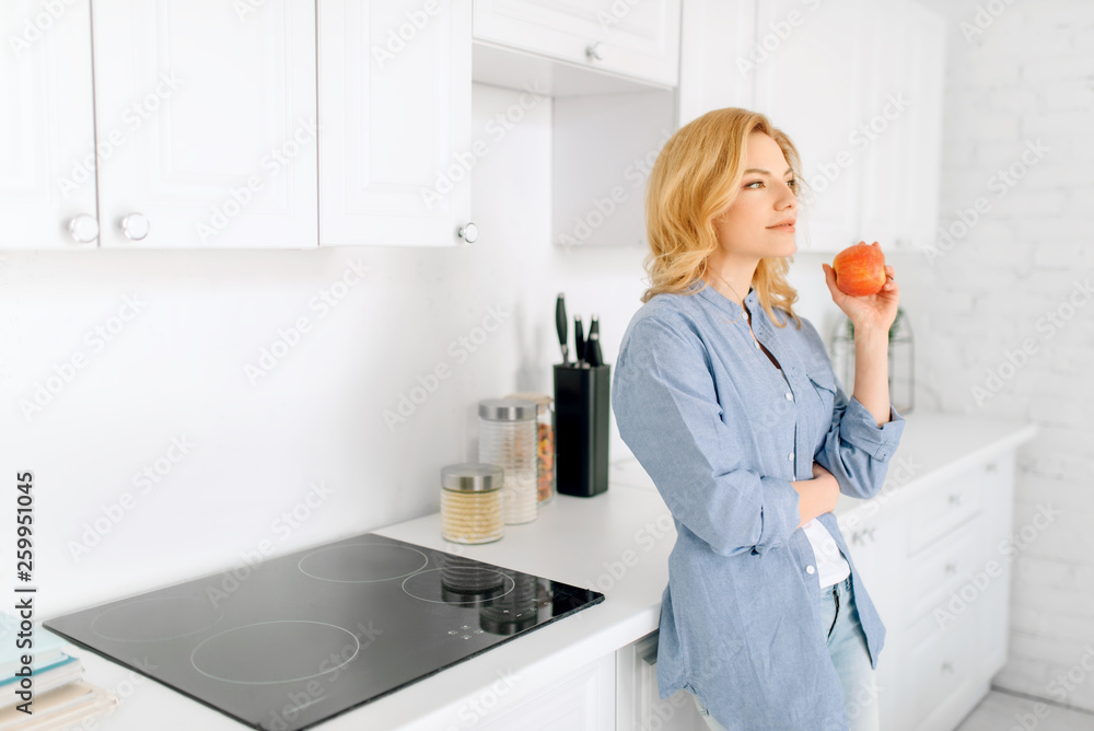 Woman poses on kitchen with snow-white interior Woman poses on kitchen with snow-white interior