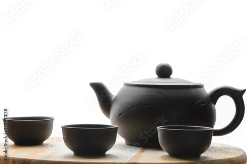 Set for tea ceremony. Large clay teapot, cups isolated on white background. Front view.
