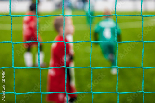 Junior Sports Soccer Background. Soccer Goal Net and Blurred Youth Players in the Background