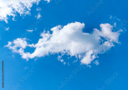 Fuffy clouds on bright blue sky background