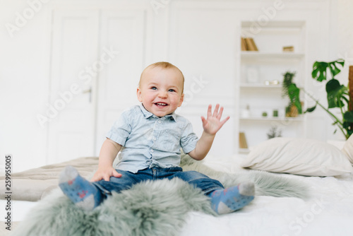 Cute little toddler boy waving his hand. Child waving hello or goodbye.