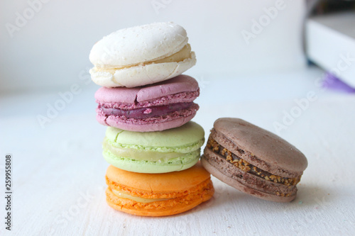 Fototapeta Naklejka Na Ścianę i Meble -  Colorful French or Italian macaroon stack cakes / Macaroon cakes. Assorted macaroon cakes stacked on top of each other on a light background. Copy space. Delicious dessert.